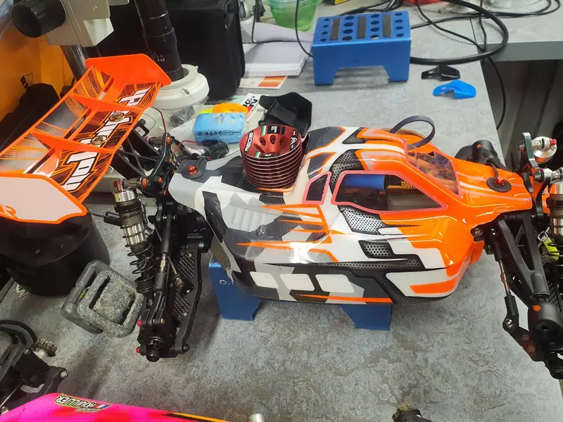 Buggy RC orange camouflage préparé sur l'établi