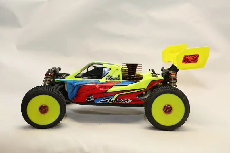 Buggy RC jaune de compétition vu de profil